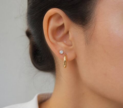 Realistische close-up van iemand met stijlvolle oorbellen in een neutrale setting