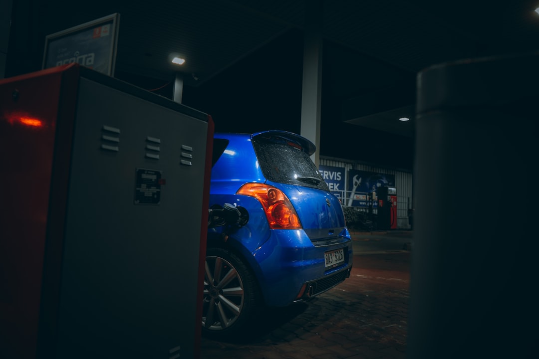blue car parked near white building