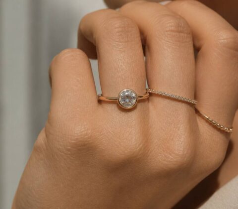 Realistische foto van een hand met meerdere ringen bij daglicht, gericht op de details van de sieraden