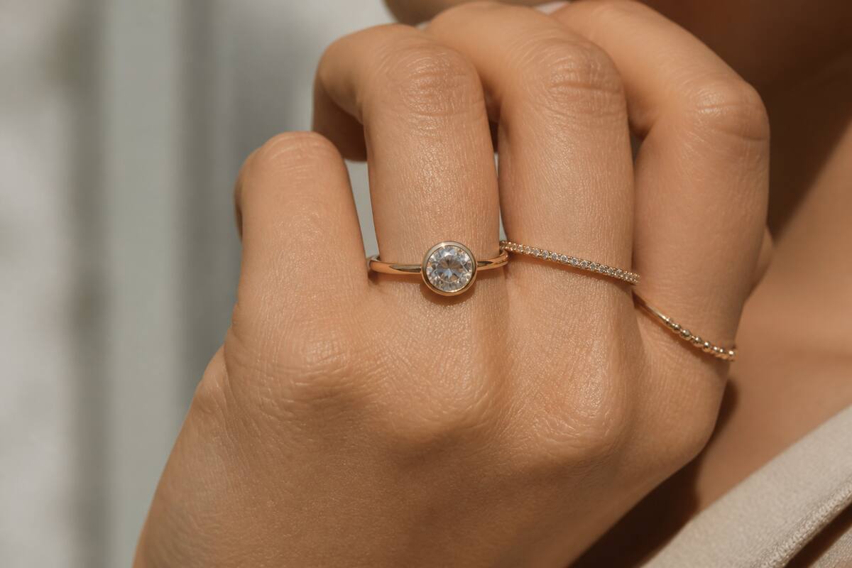 Realistische foto van een hand met meerdere ringen bij daglicht, gericht op de details van de sieraden